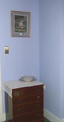 A small cabinet to rest your luggage next to the closet.